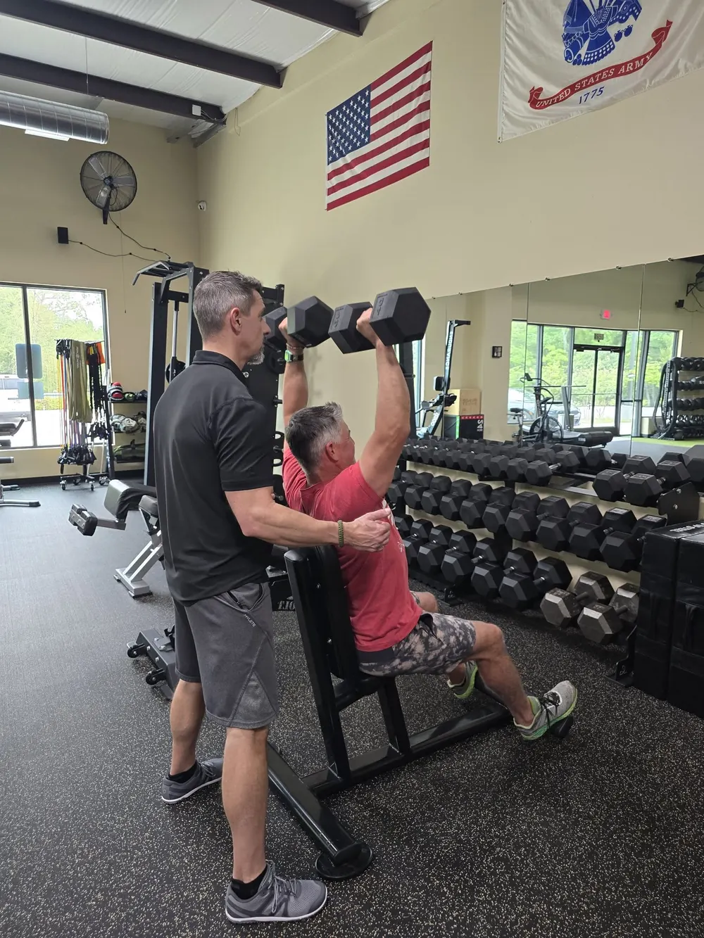 Billy Anderson spotting a client through a set of incline dumbbell presses