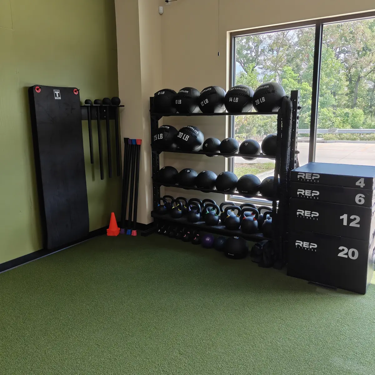 Wall balls, kettlebells and plyo boxes on the turf at Waypoint Fitness