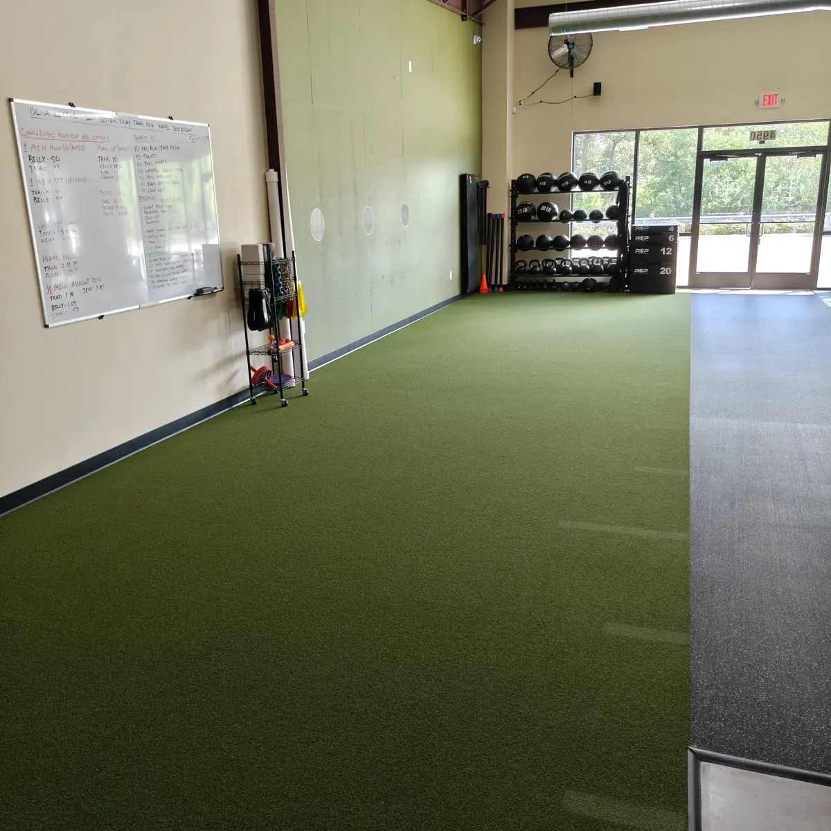 The indoor turf lane and workout whiteboard at Waypoint Fitness